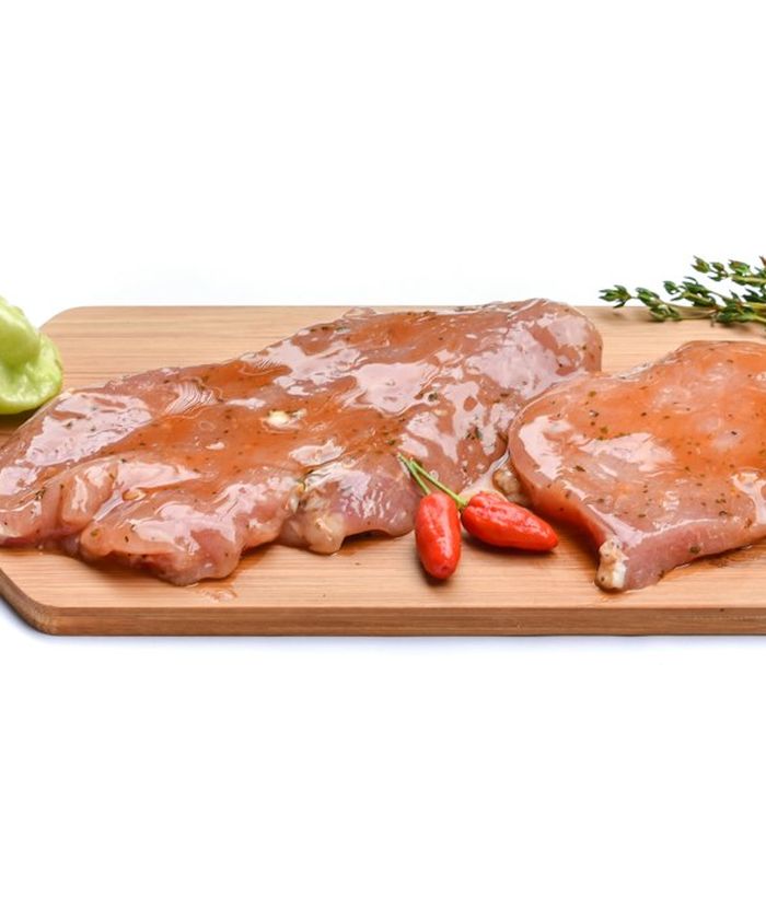 Carne crua com folhas verdes sobre uma tábua de madeira