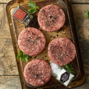 Hambúrgueres de carne moída crus em uma bandeja